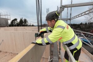 Mann med drill på byggeplass