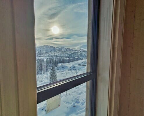 Utsikten ut vinduet om vinteren med solen imot glasset, foto.